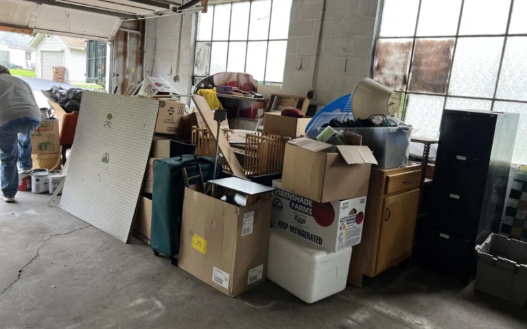 A garage packed with boxes, cabinets, a filing cabinet and furniture waiting to be cleared out