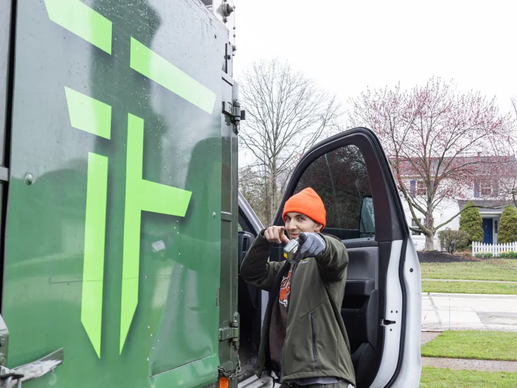 Fly By Junk Haulers truck door with a crew member at the open cab
