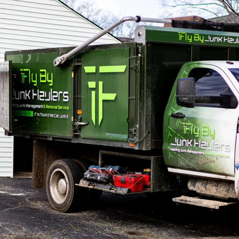 Fly By Junk Haulers dump truck with the company logo and lettering on the side