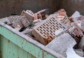 Broken clay ceramic bricks from a ruined wall lie scattered on a construction site, representing construction waste