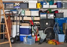 Overloaded suburban garage.  Boxes, coolers, sporting gear and more.