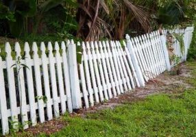 Old rickety fence in need of painting, fixing or replacing.